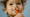 A child with a LEGO DUPLO animal in their mouth