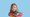 A red-haired child holding a LEGO creation and looking straight into the camera